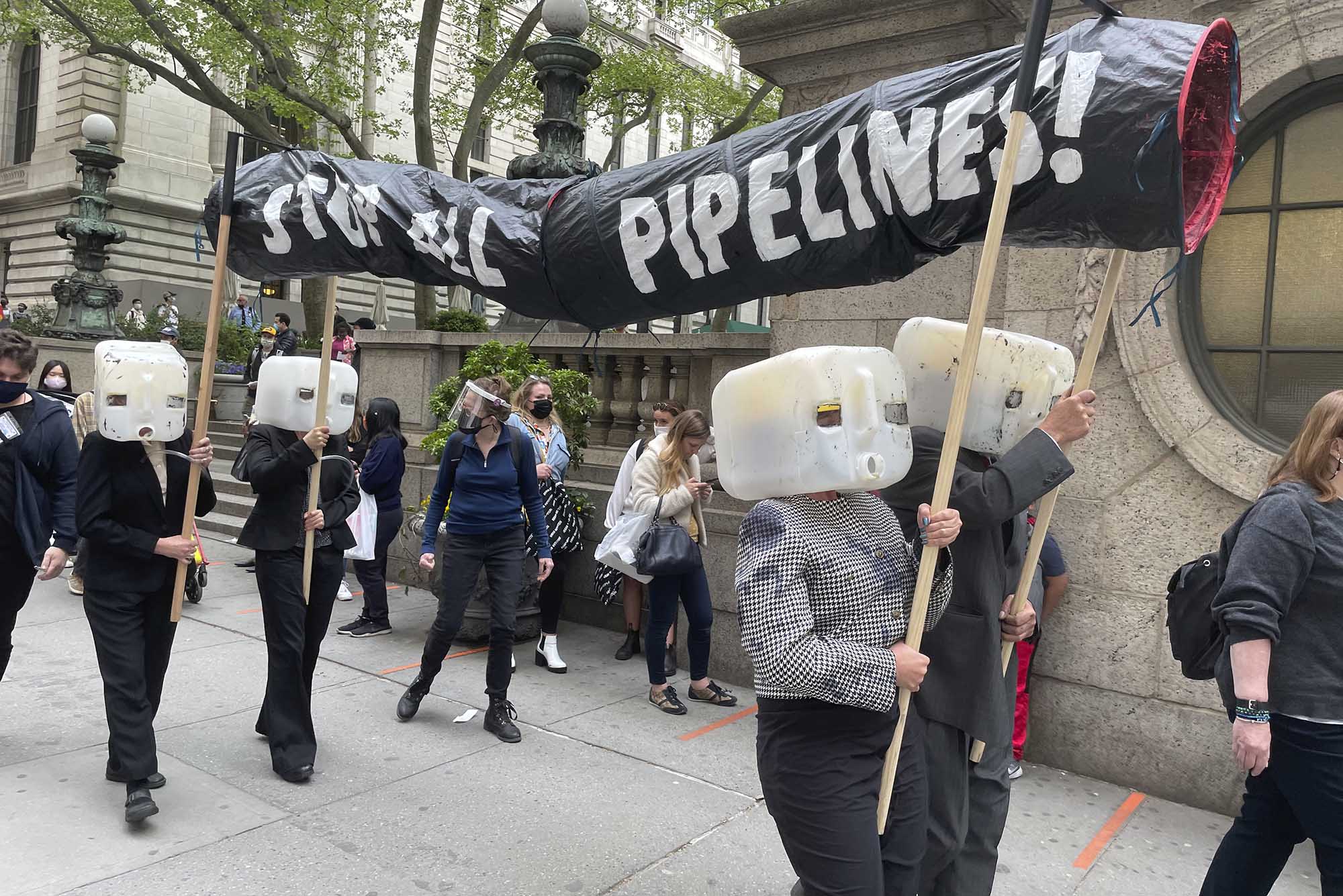 Photo: Environmentalists help bring an end to further construction of the Keystone XL oil pipeline project, which contributes to the use of fossil fuels linked to pollution, environmental degradation and global warming. They protest with plastic jugs on their heads and a paper pipe which reads STOP ALL PIPELINES.