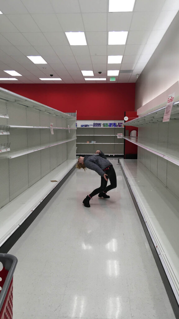 Photo: A man bending backwards in a bare asile in Target.