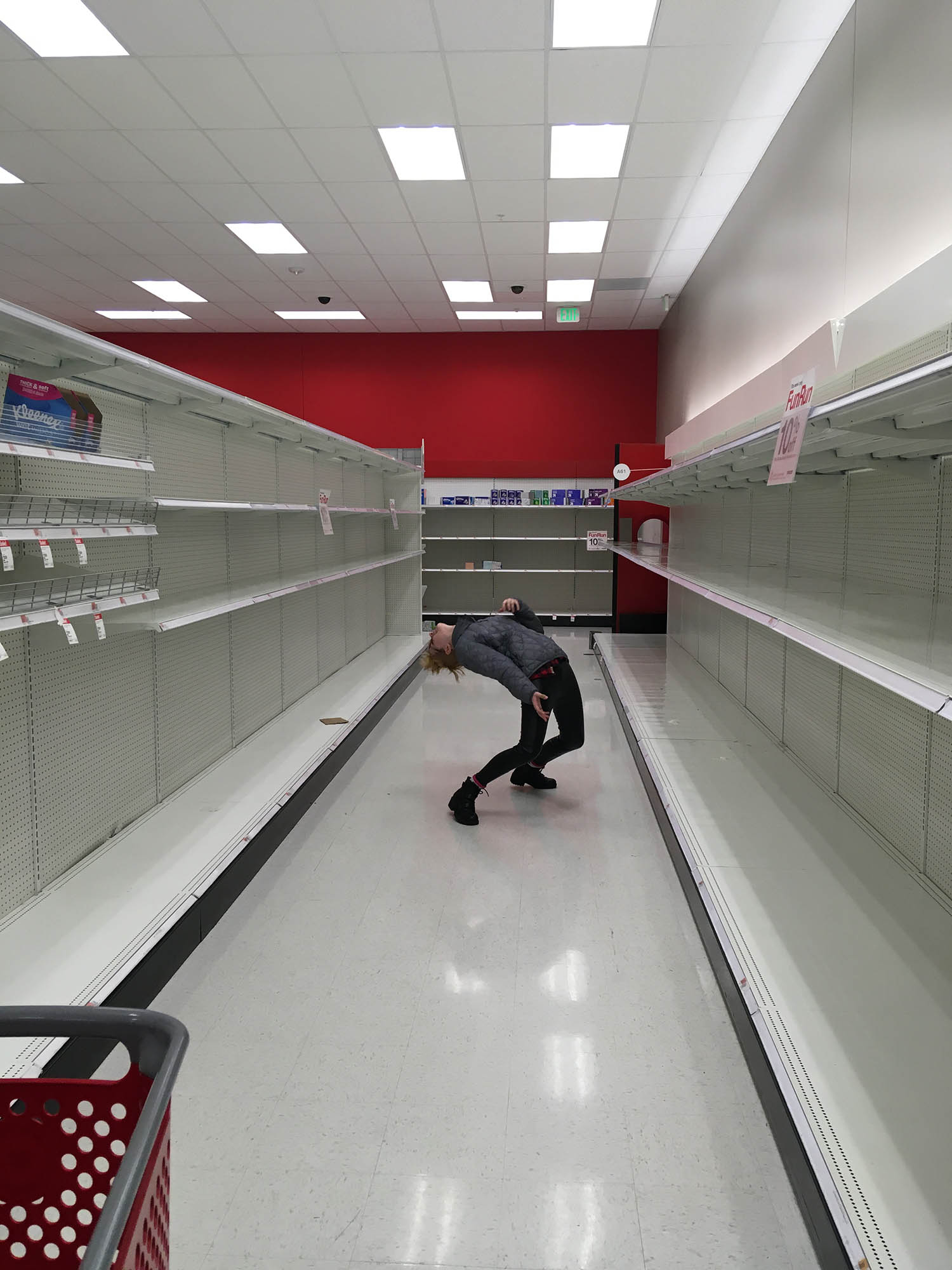 Photo: A man bending backwards in a bare asile in Target.