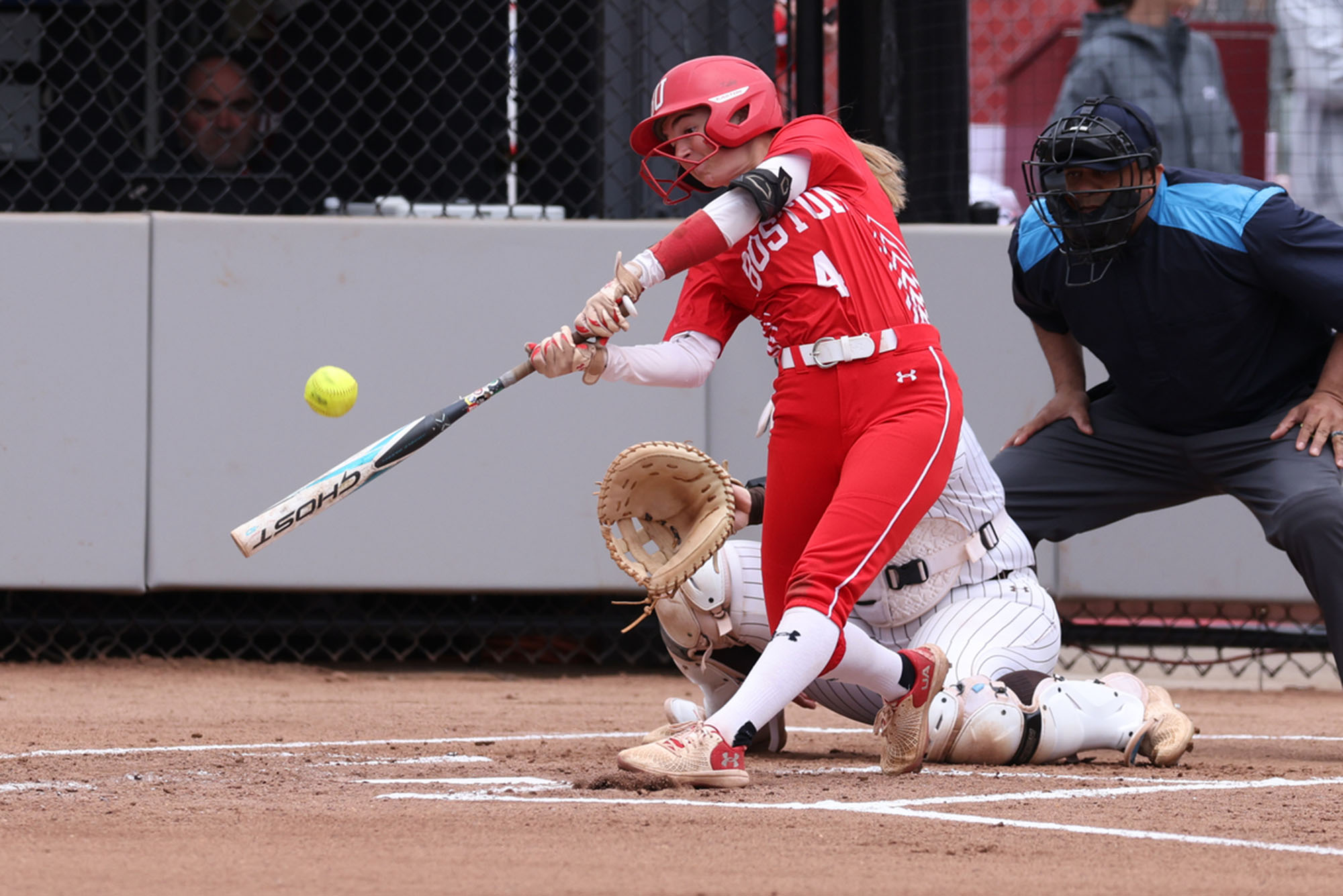Photo: A picture of a girl in a red softball uniform with white accents up at bat