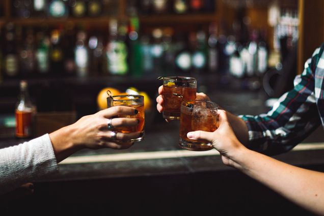 Photo: A picture of three cocktails being raised in a cheers at a bar