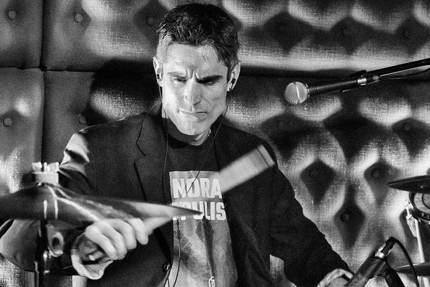 Photo: A black and white picture of Gareth Dylan Smith, a CFA professor, playing the drums on stage