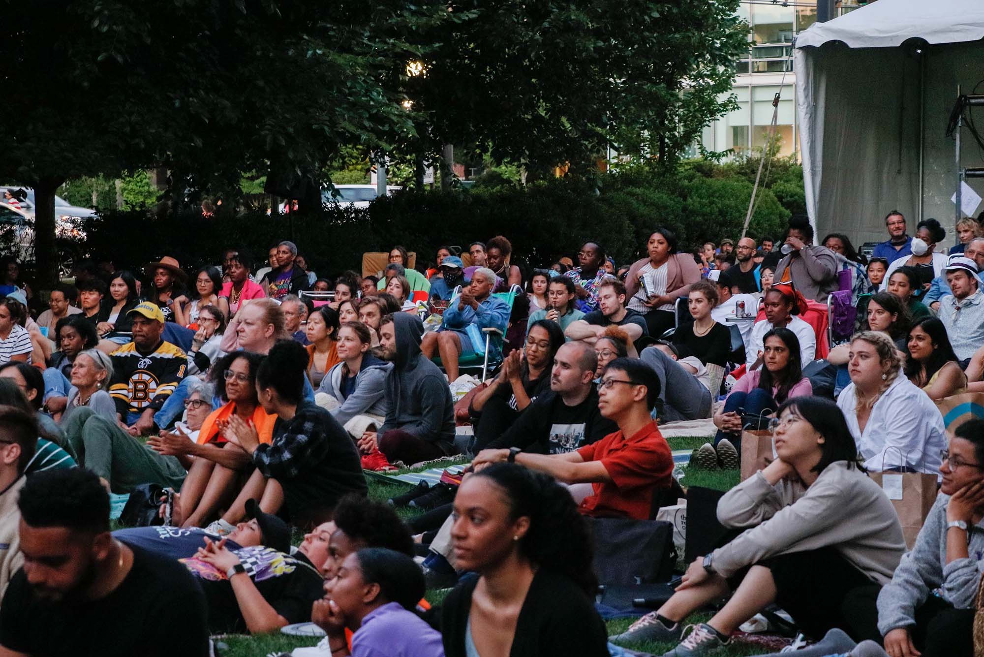 Photo: A picture of people sitting outside and watching a film during a film festival