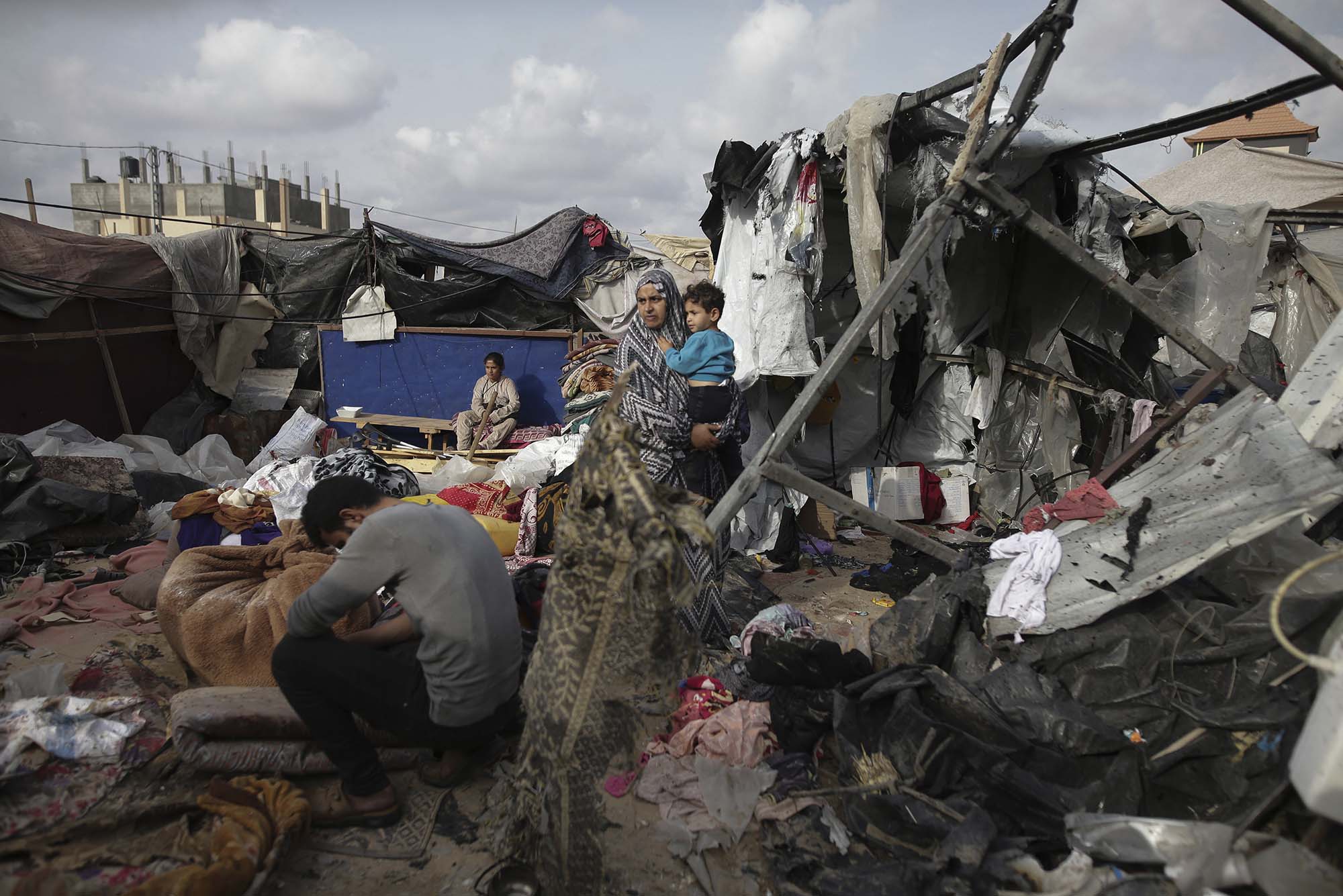 Photo: Displaced Palestinians inspect their tents destroyed by Israel's bombardment, adjunct to an UNRWA facility west of Rafah city, Gaza Strip. Amongst the destruction, a mom holds her child in her hands, surveying the damage.