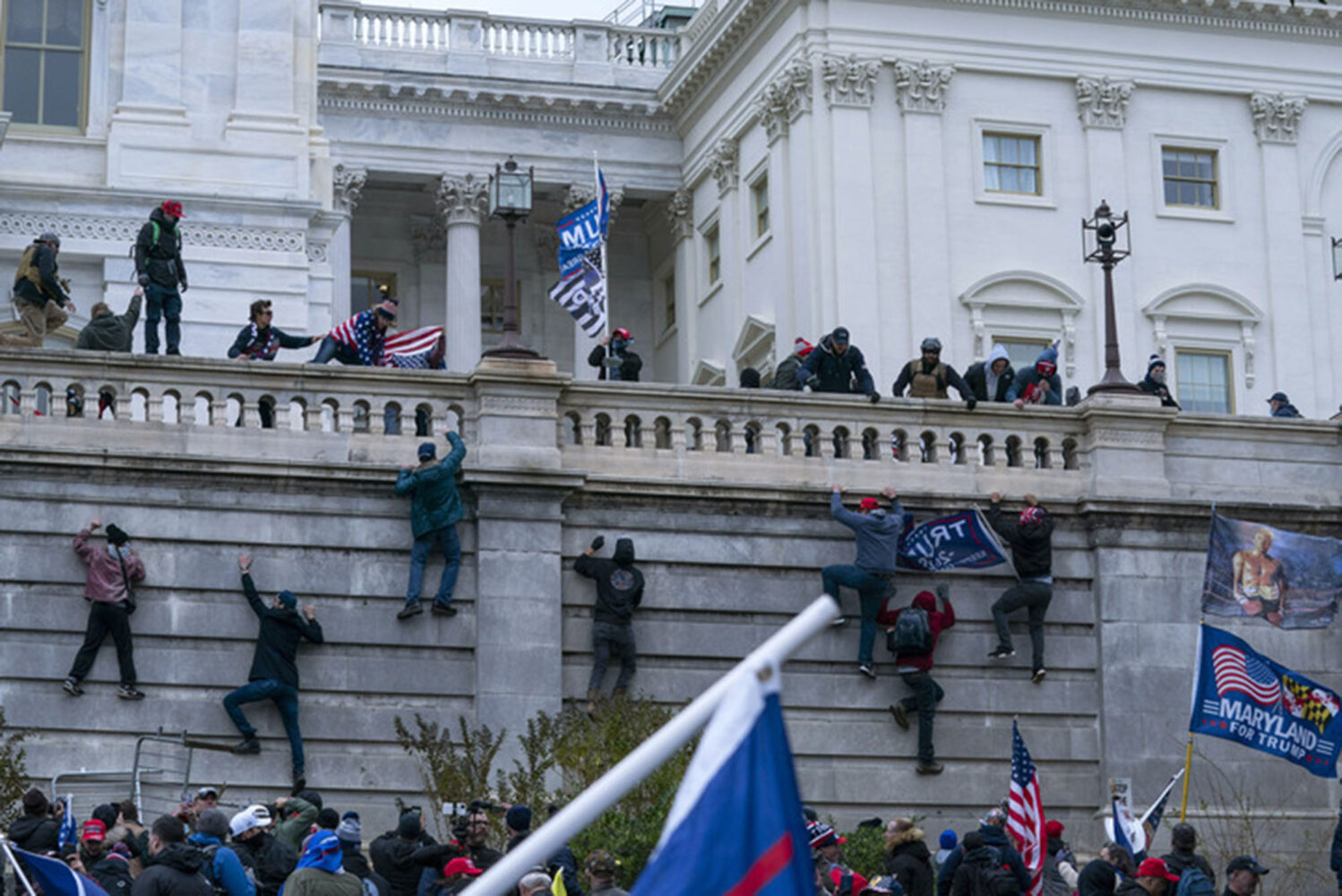 Photo: A photo from January 6th, with people attempting to climb the walls of the Capitol building.