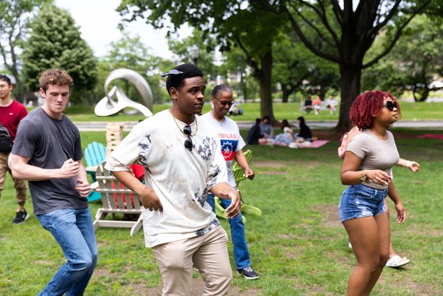 Photo: A picture of people dancing on a lawn during a picnic celebration