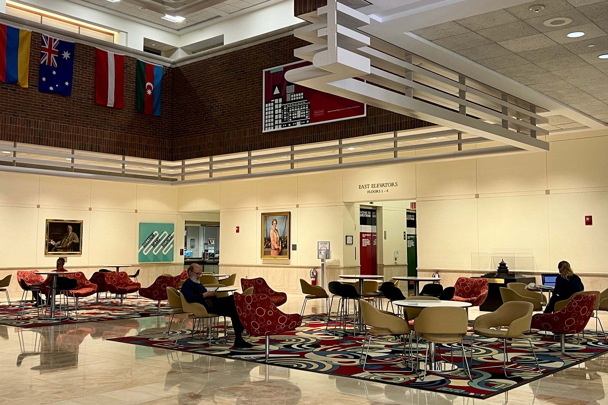 Photo: A picture of the inside of a college academic building with tables and chairs for studying