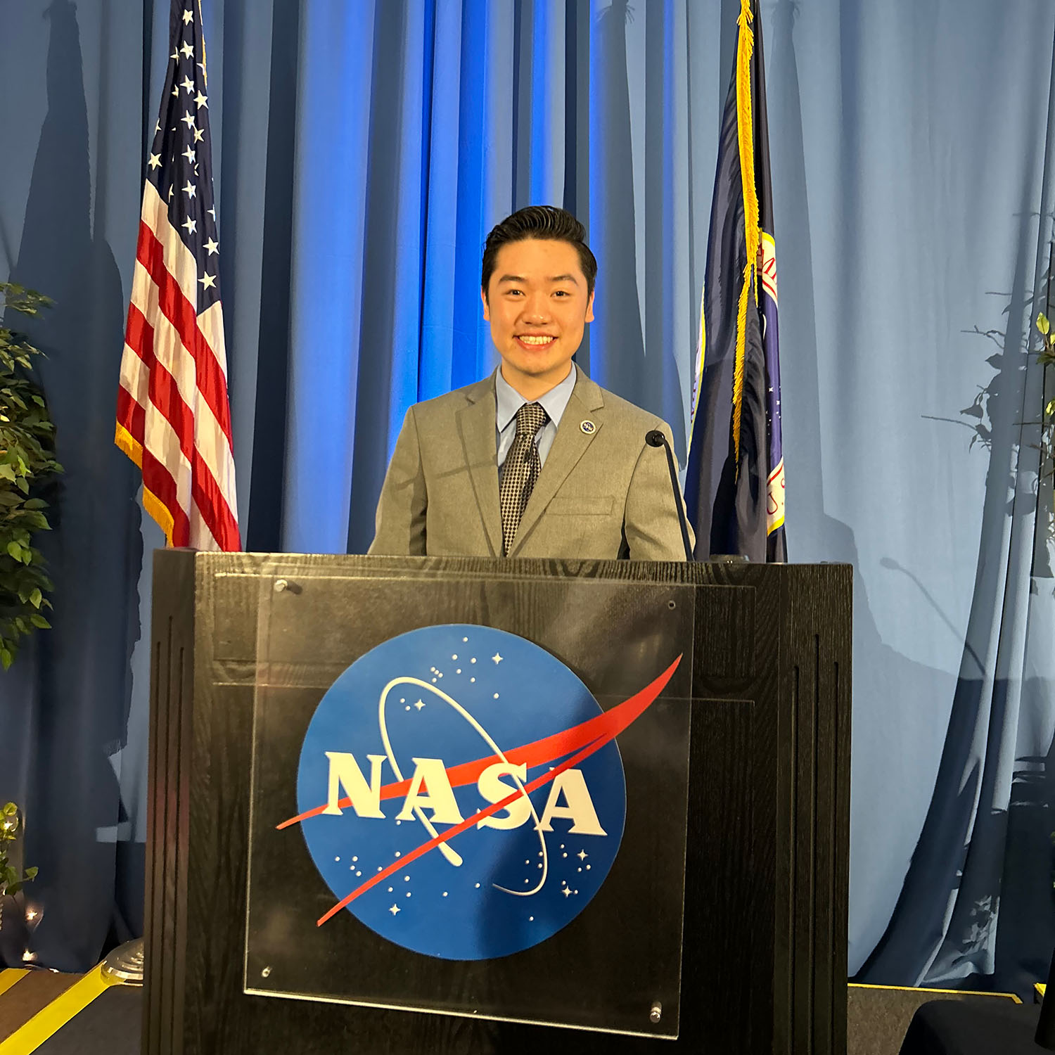 Photo: A picture of a man with black hair wearing a gray suit behind a podium that says "NASA"