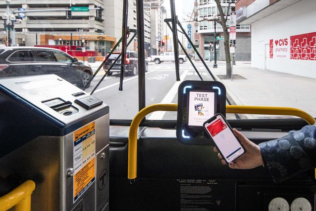 Photo: A picture of someone using Apple Pay on their smartphone in order to pay for bus fare