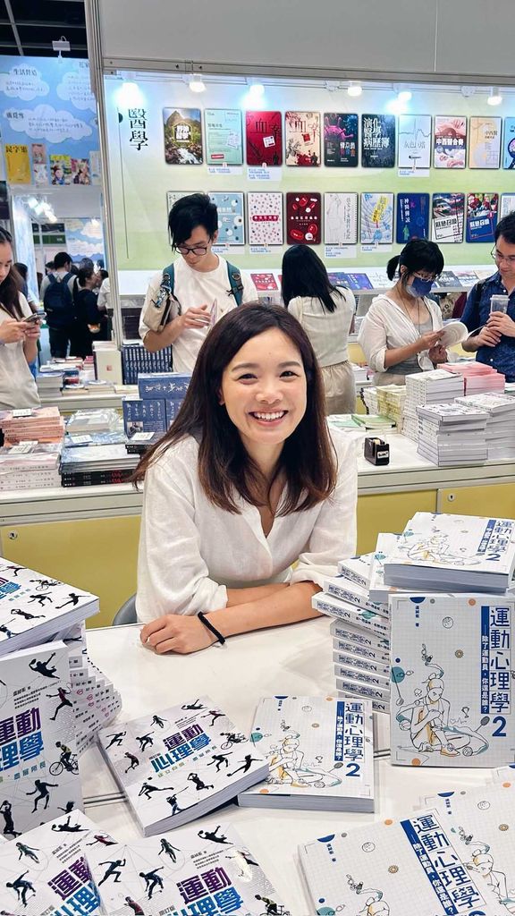 Photo: A portrait shot of Karen Lo, a young woman with short hair and a white button up. She smiles for the photo at a table.