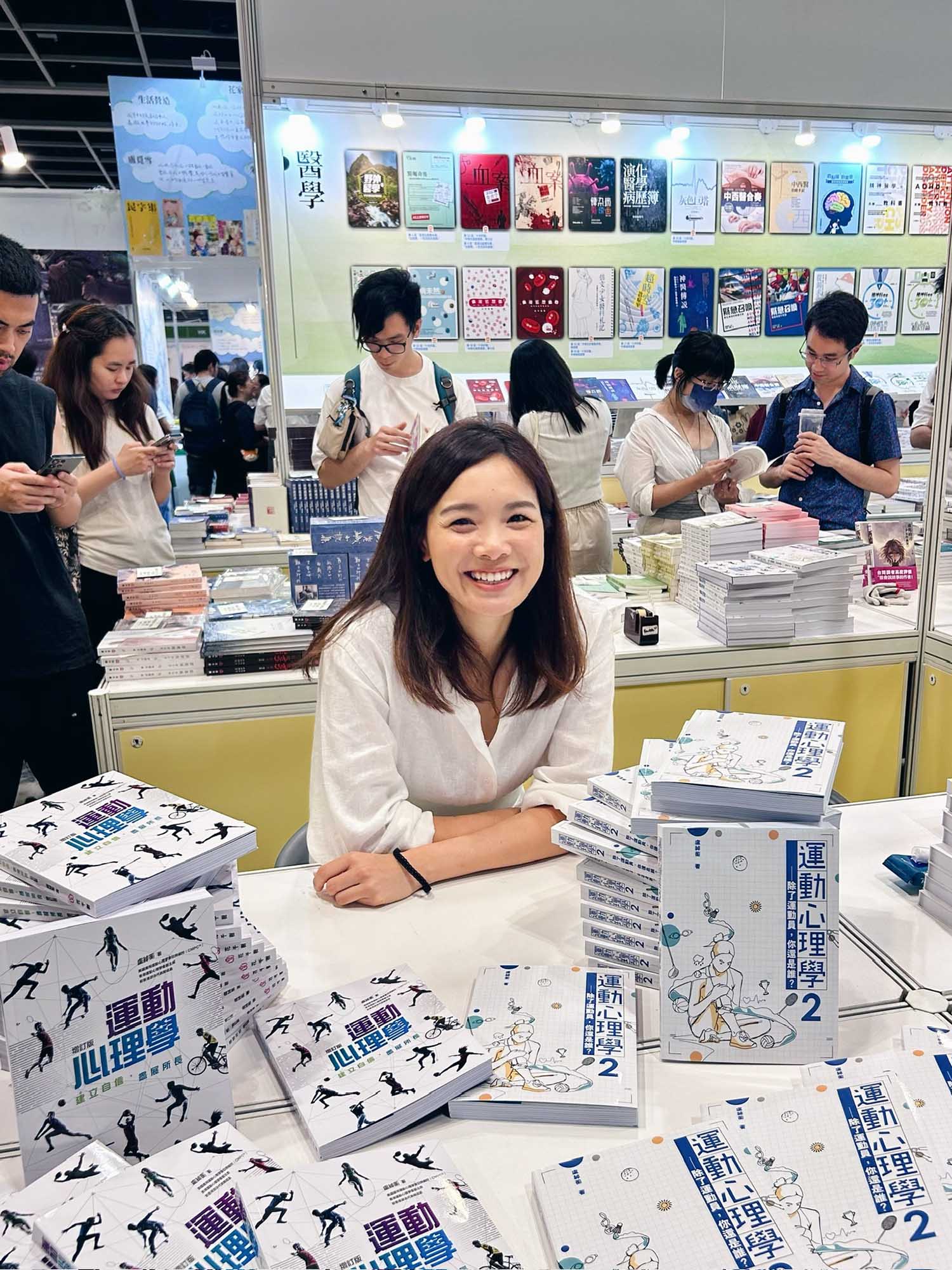Photo: A portrait shot of Karen Lo, a young woman with short hair and a white button up. She smiles for the photo at a table.