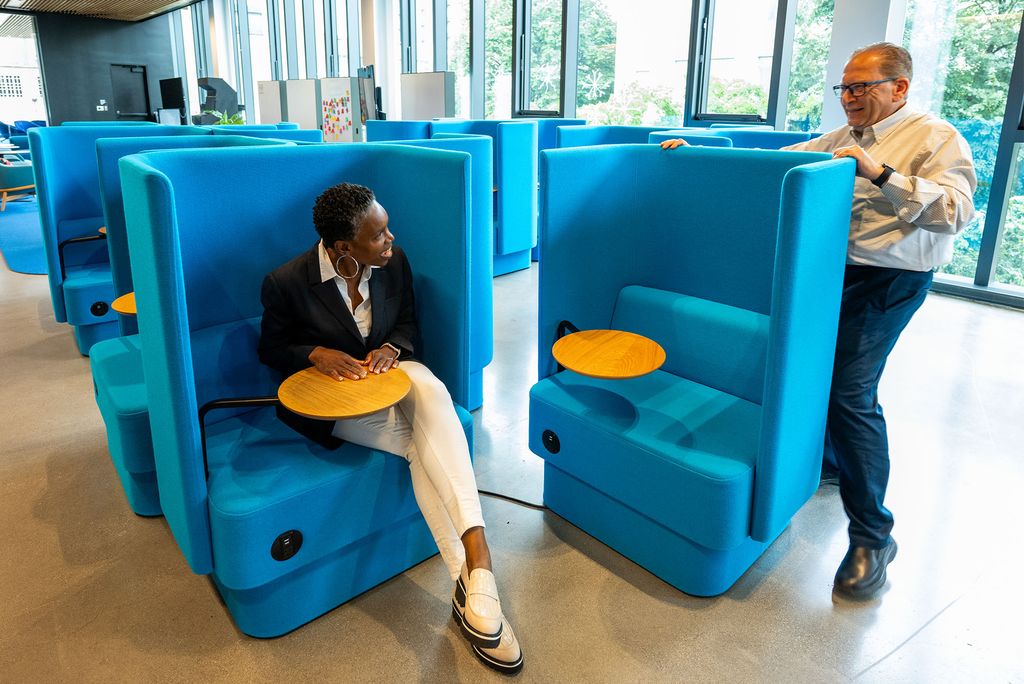 Photo: Large blue chairs in which the new BU president takes a seat as onlookers seem pleased
