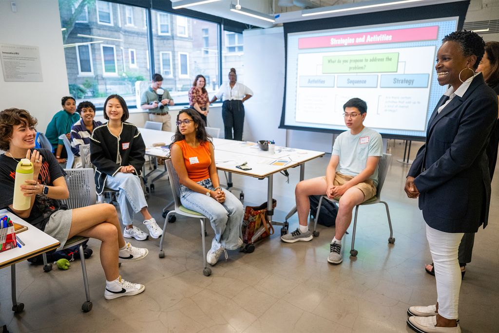 Photo: A group of students present ideas to Boston University's newest president in a classroom setting