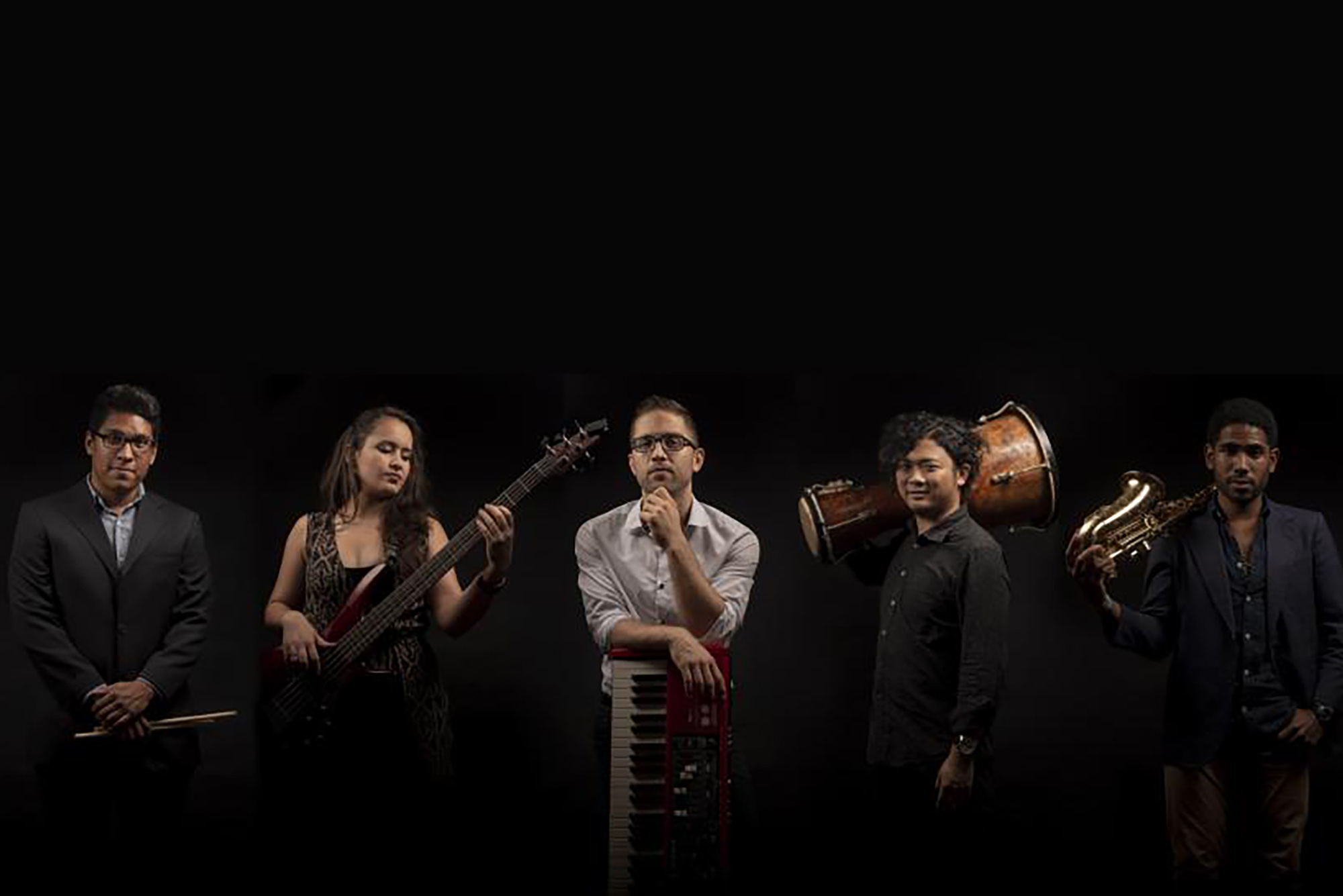 Photo: A lineup of musicians posing with their instruments dramatically.