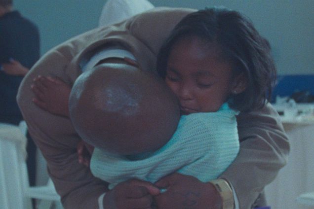 Photo: A black father holds his daughter in a tight hug/embrace