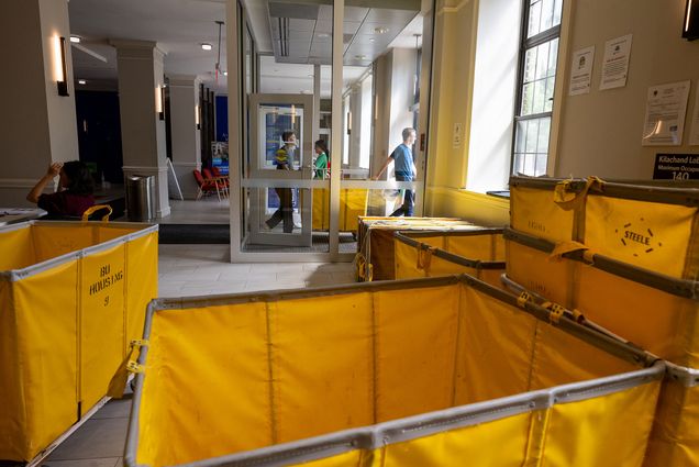 Photo: Many yellow bins with "BU Housing" on the side gathered in a lobby