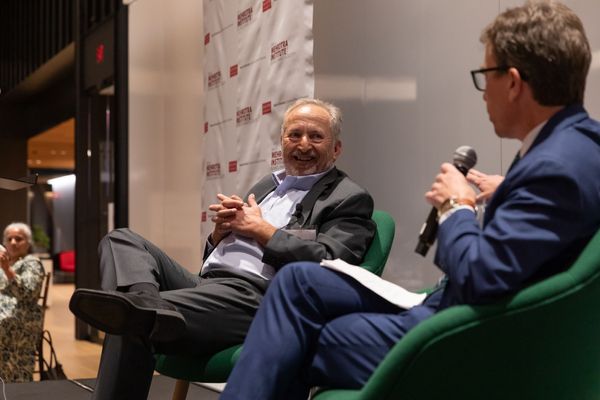 Photo: Larry Summers and a man interviewing him sitting in chairs in front of an audience