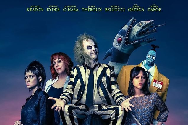 Photo: A crop of a movie poster with white Beetlejuice, a man with a skull-like face paint and wild green hair, sits next to two women on his right and one on his left.