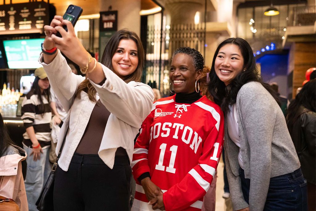 Photo: Sophia Caffrey (left) (COM 25) and Kayla Lok (COM 27) take a selfie with President Melissa Gilliam during BU Night at Time Out Market on September 23, 2024. The evening was for students to meet President Gilliam, this indoor “block party” will featured music from a jazz combo of BU students, free swag, and discounted food and drinks for students.Jackie Ricciardi for Boston University Photography