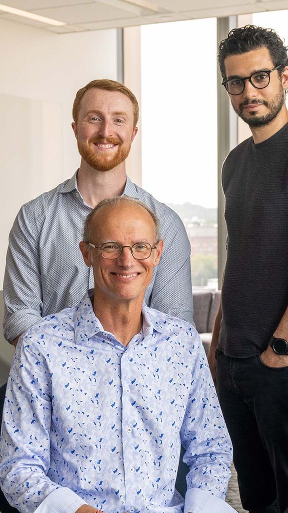 Photo: A group of five engineering researchers pose for formal headshots, they are all wearing business casual attire in a brightly lit modern space