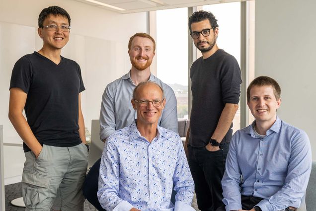 Photo: A group of five engineering researchers pose for formal headshots, they are all wearing business casual attire in a brightly lit modern space