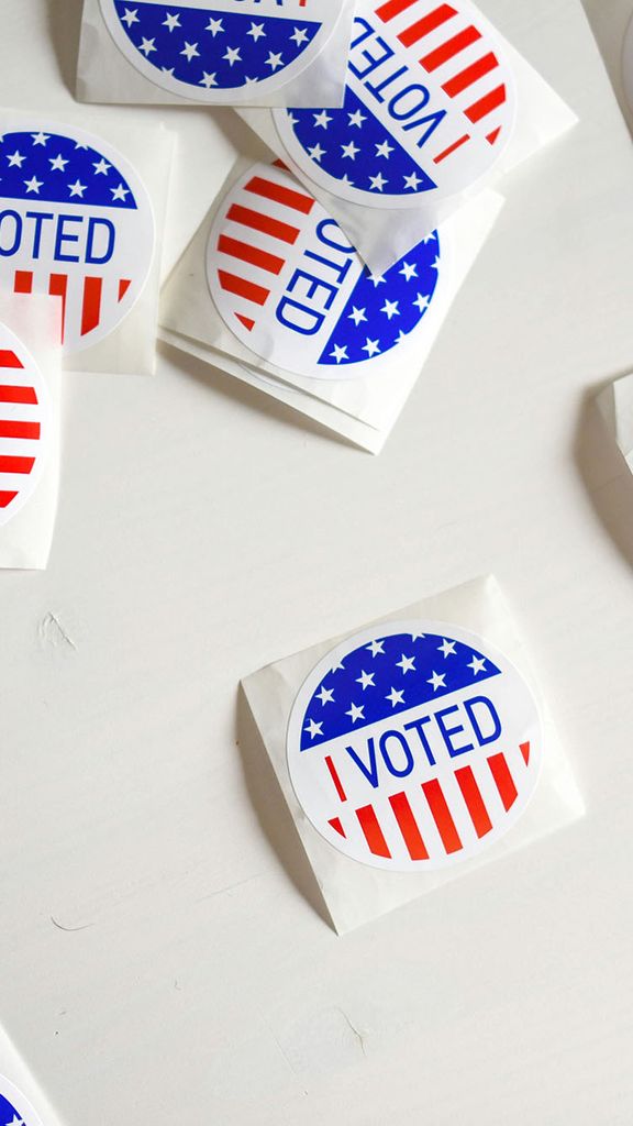 Photo: Many small, round stickers with an American flag print that say "I Voted" in blue text