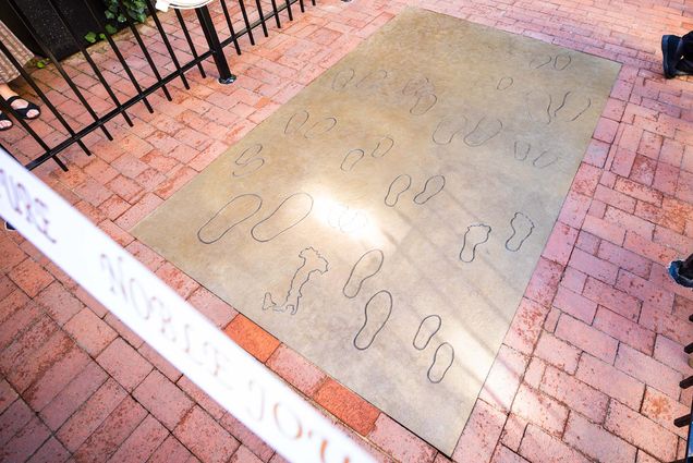 Photo: “The Noble Journey,” a sculpture by Sculptor Nancy Schön, at the steps of St. Leonard Church in The North End. The sculpture looks like many sets of footprints engraved on the ground