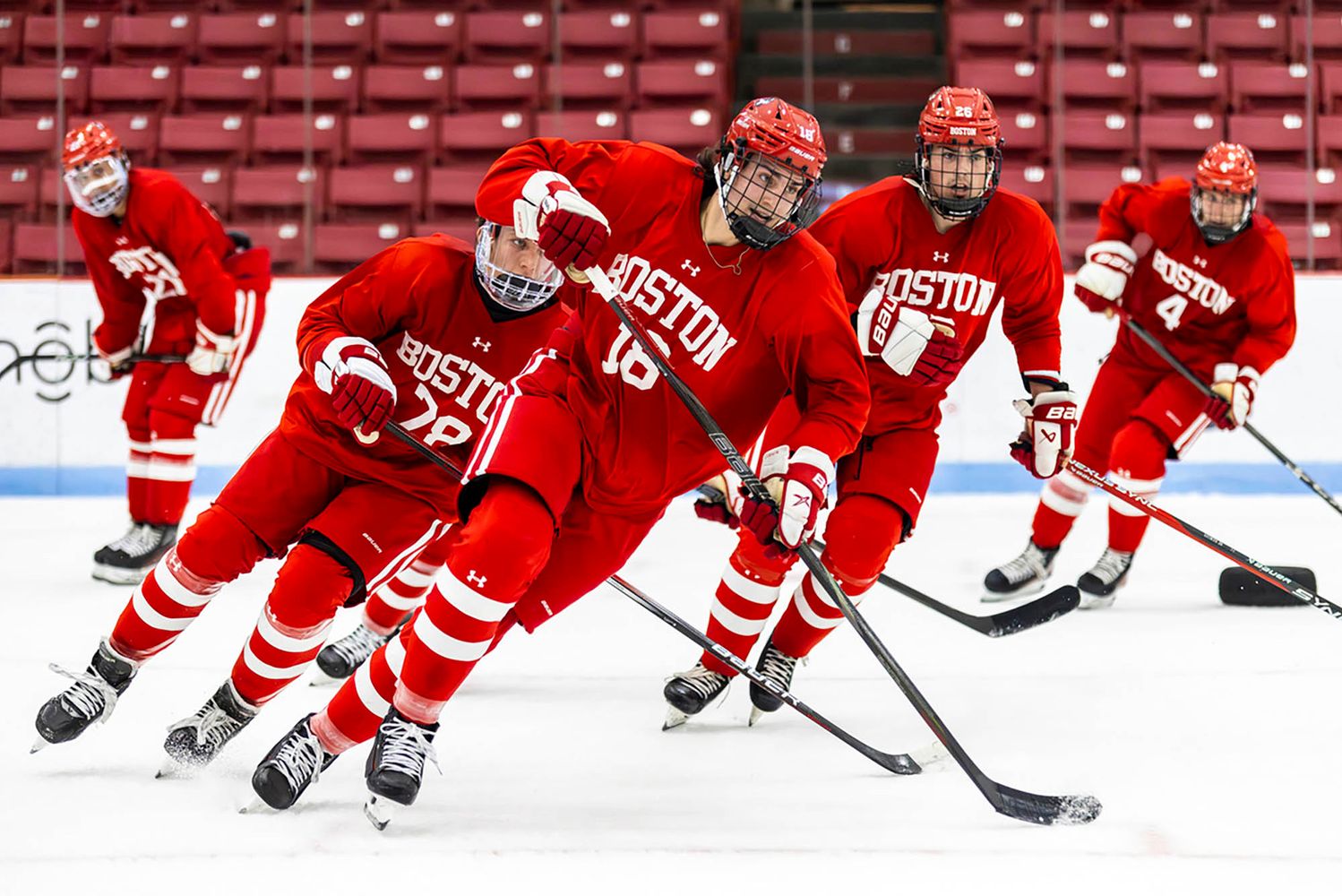 Photo: A group of hockey players on the ice skating to the right