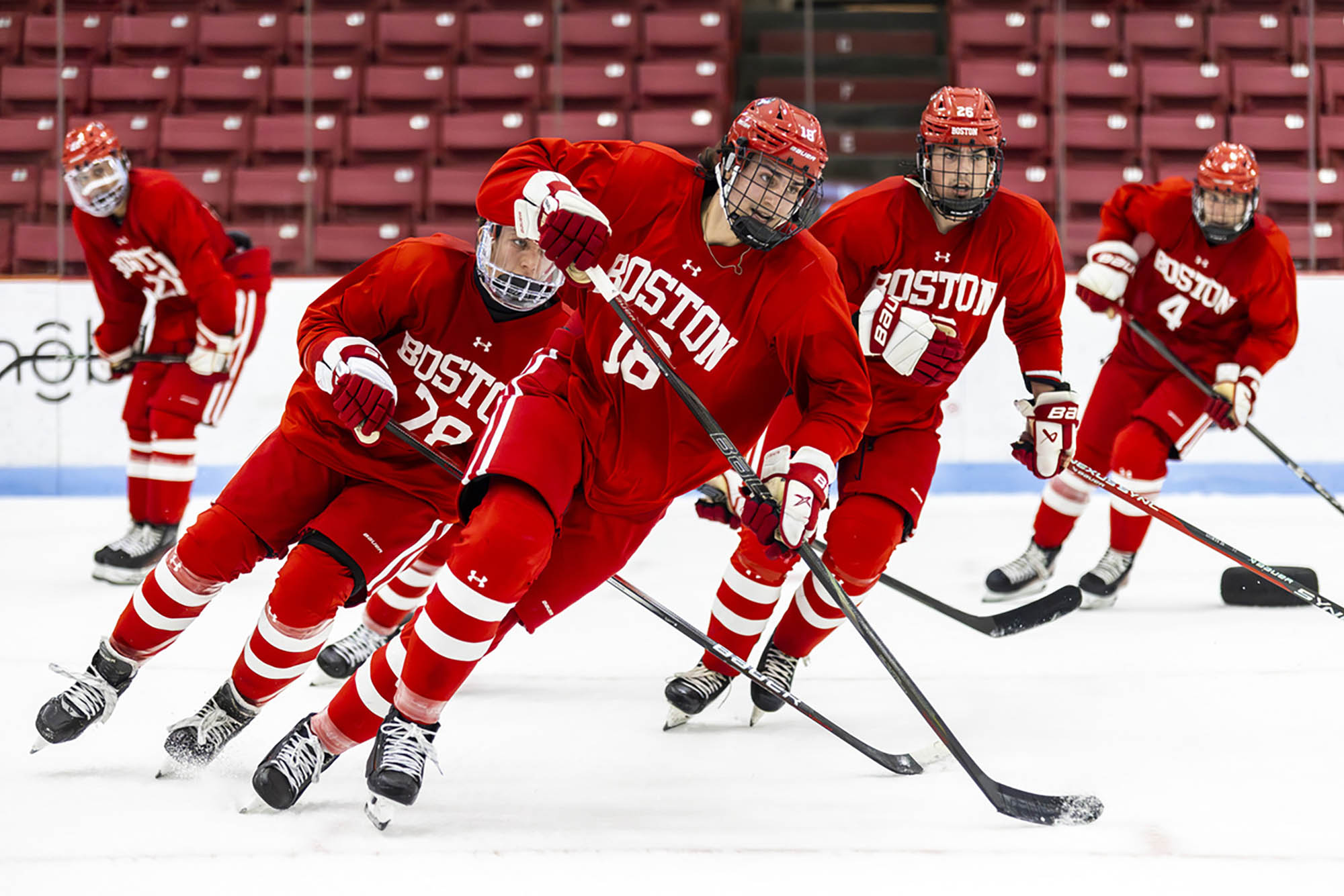 Photo: A group of hockey players on the ice skating to the right