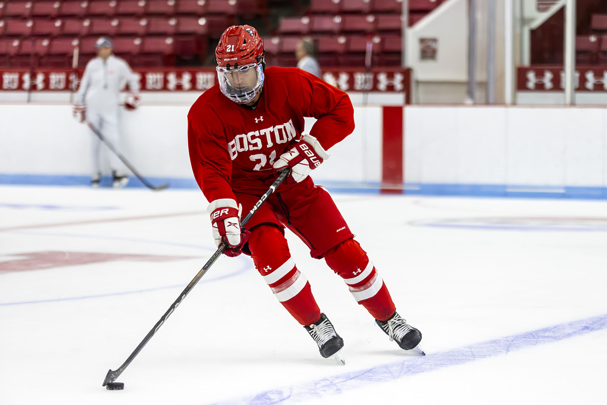 Photo: A BU hockey player skating to the left.