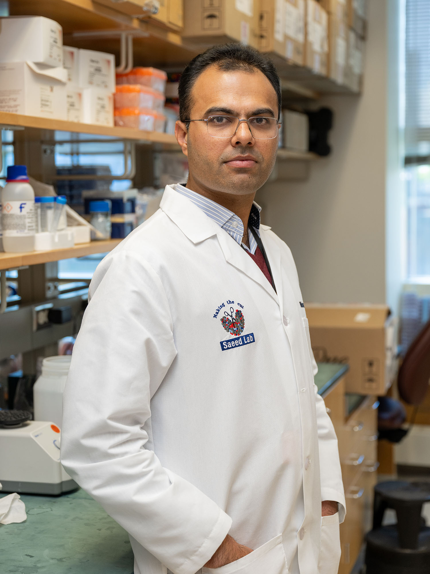 Photo: A man in a labcoat posing with his hand in his pocket