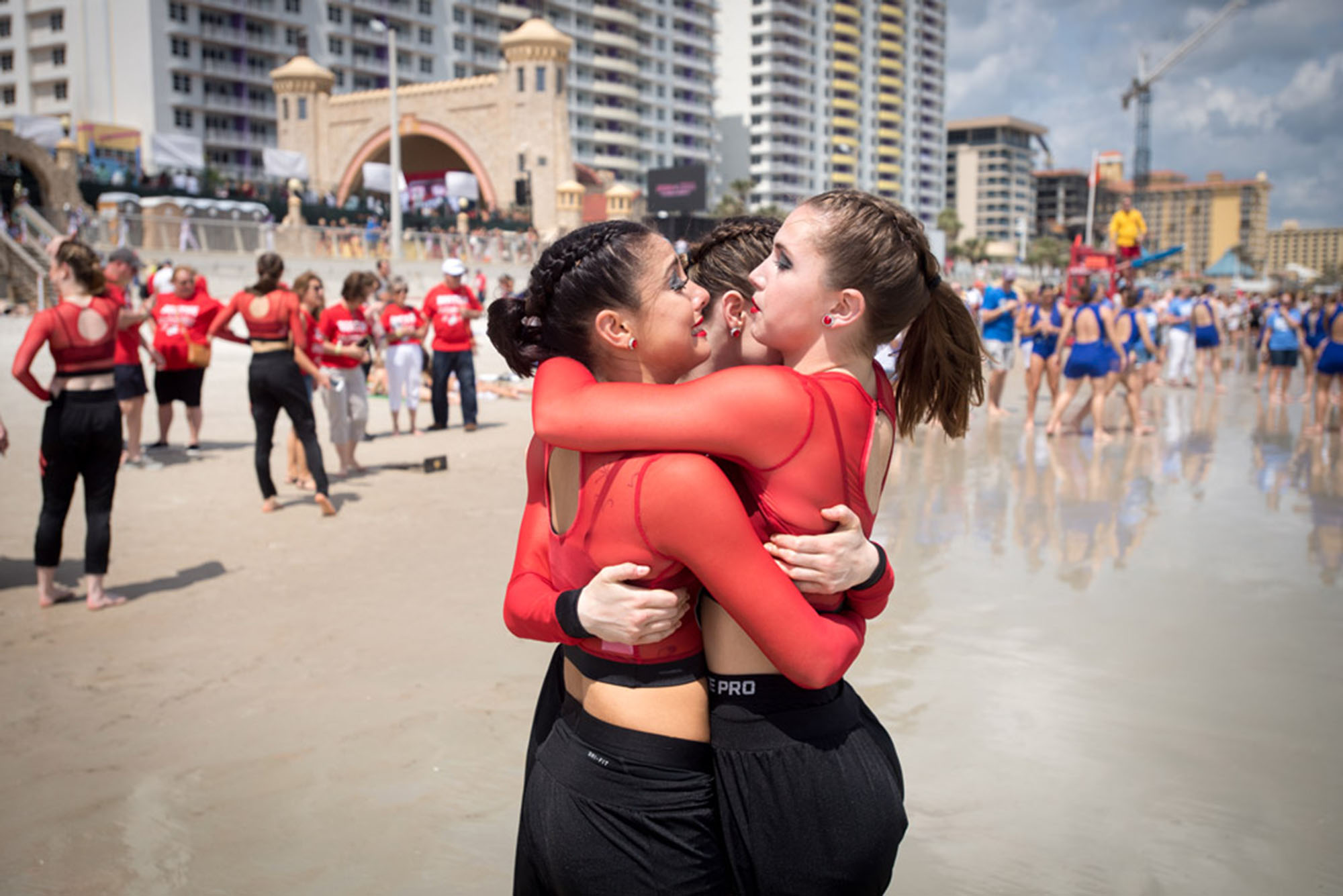 Photo: Female students from the BU Dance Team hugging and celebrating in a public plaza