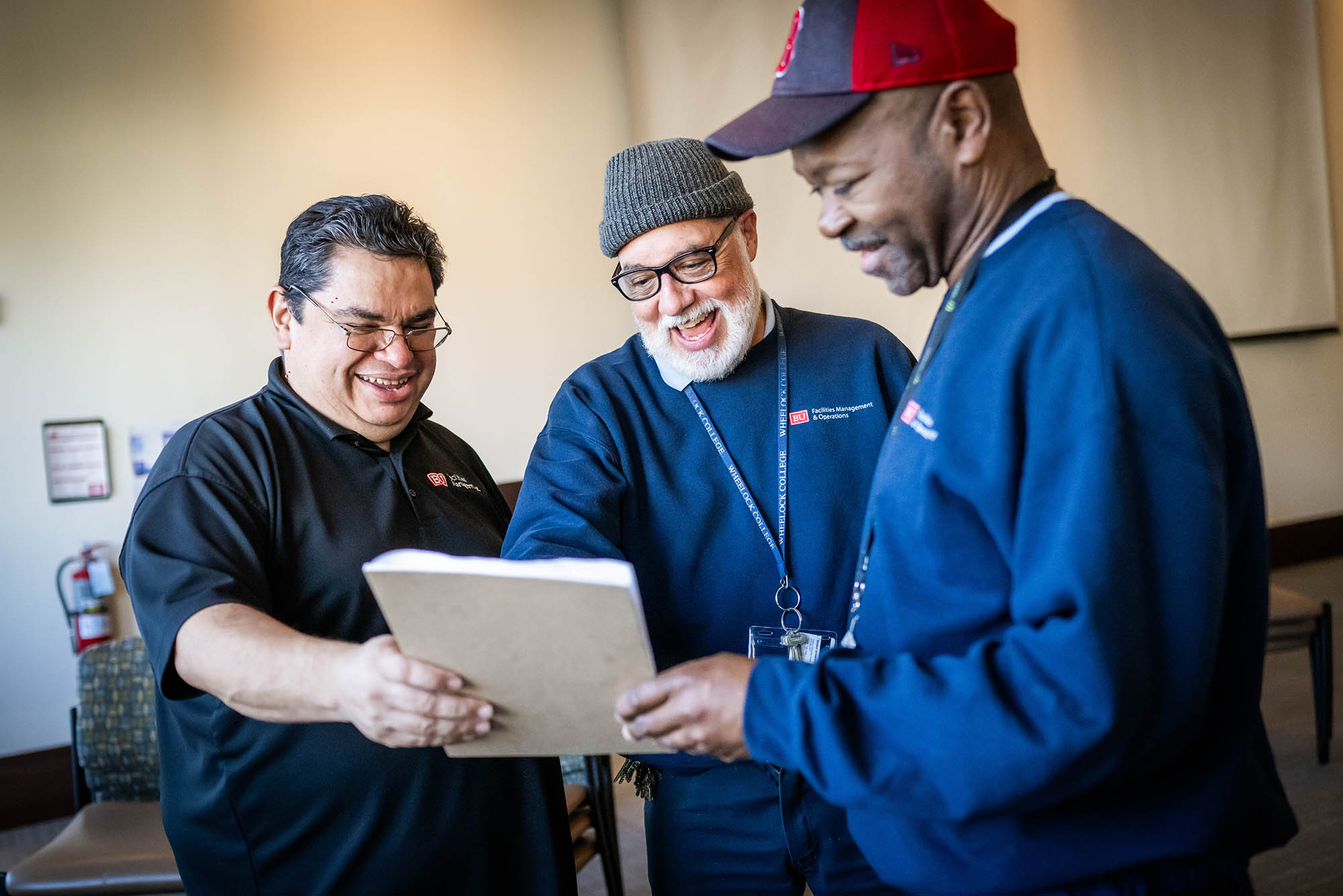 Photo: Frank Romero (left) goes over seating plans with custodians, Walter Reyes (center ) and Cloyde Osborne