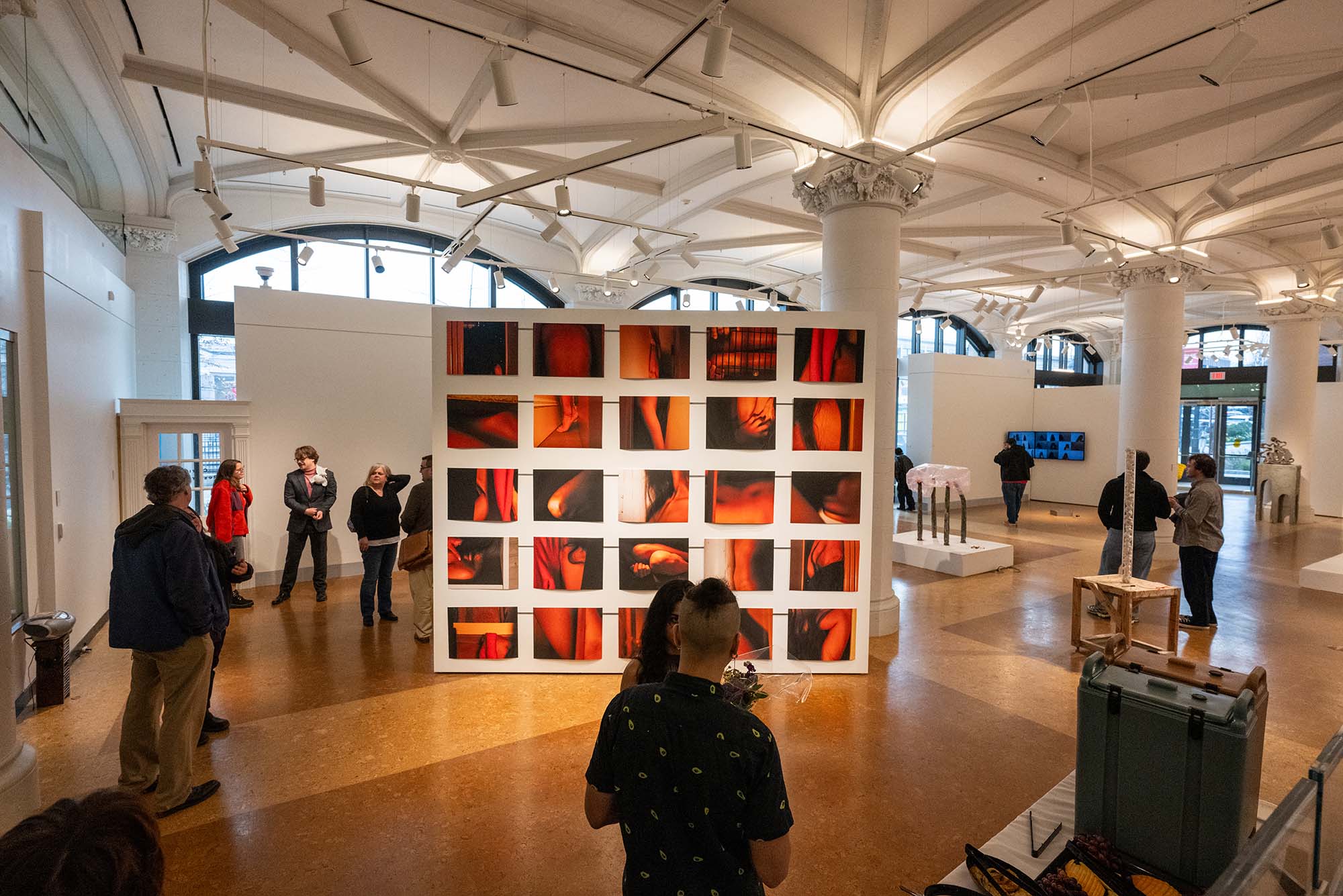 Photo: An exhibit from Boston University's MFA thesis exhibition. Thre are many red-toned prints hung on a wall