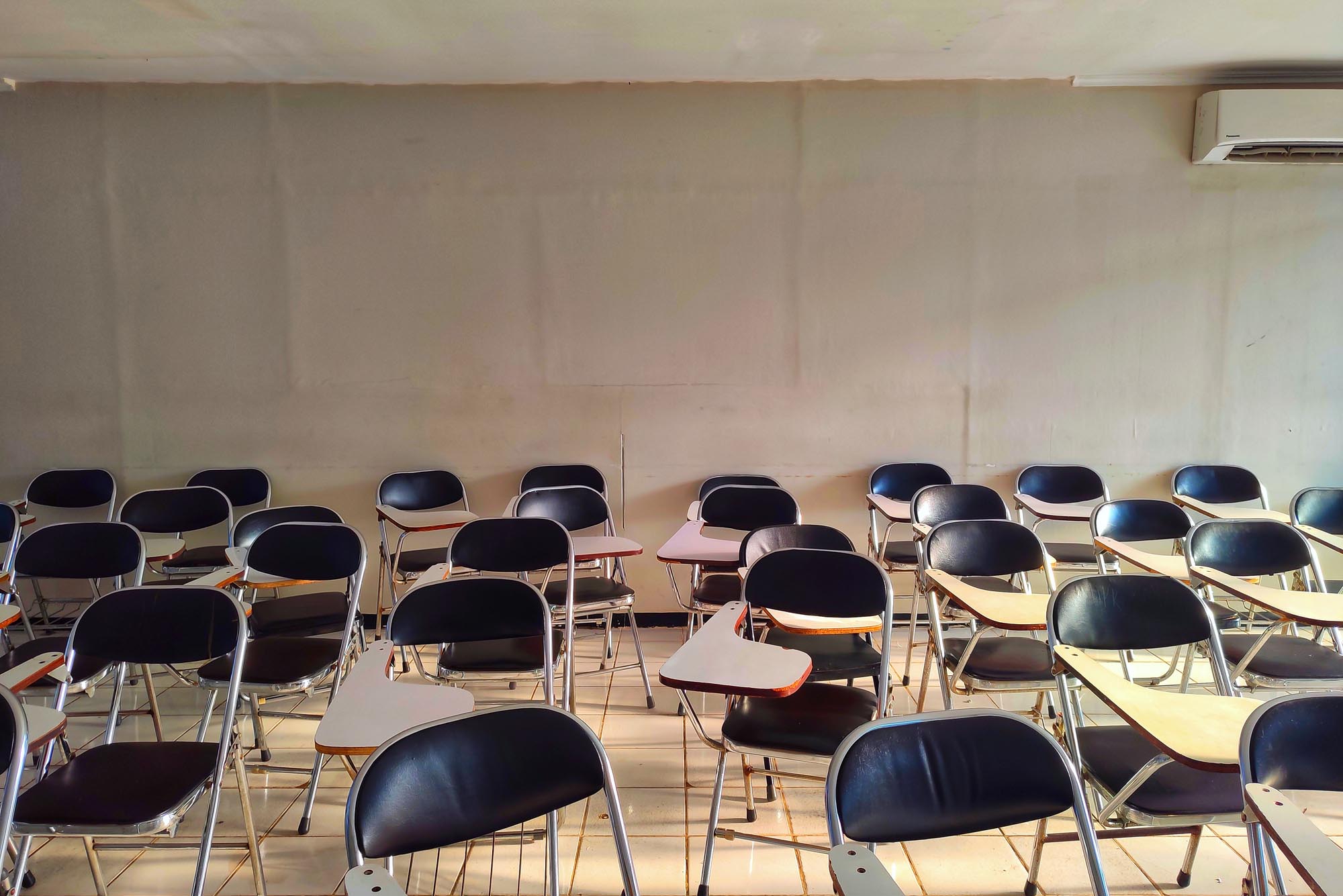 Photo: A empty classroom with desk strewn about the place.