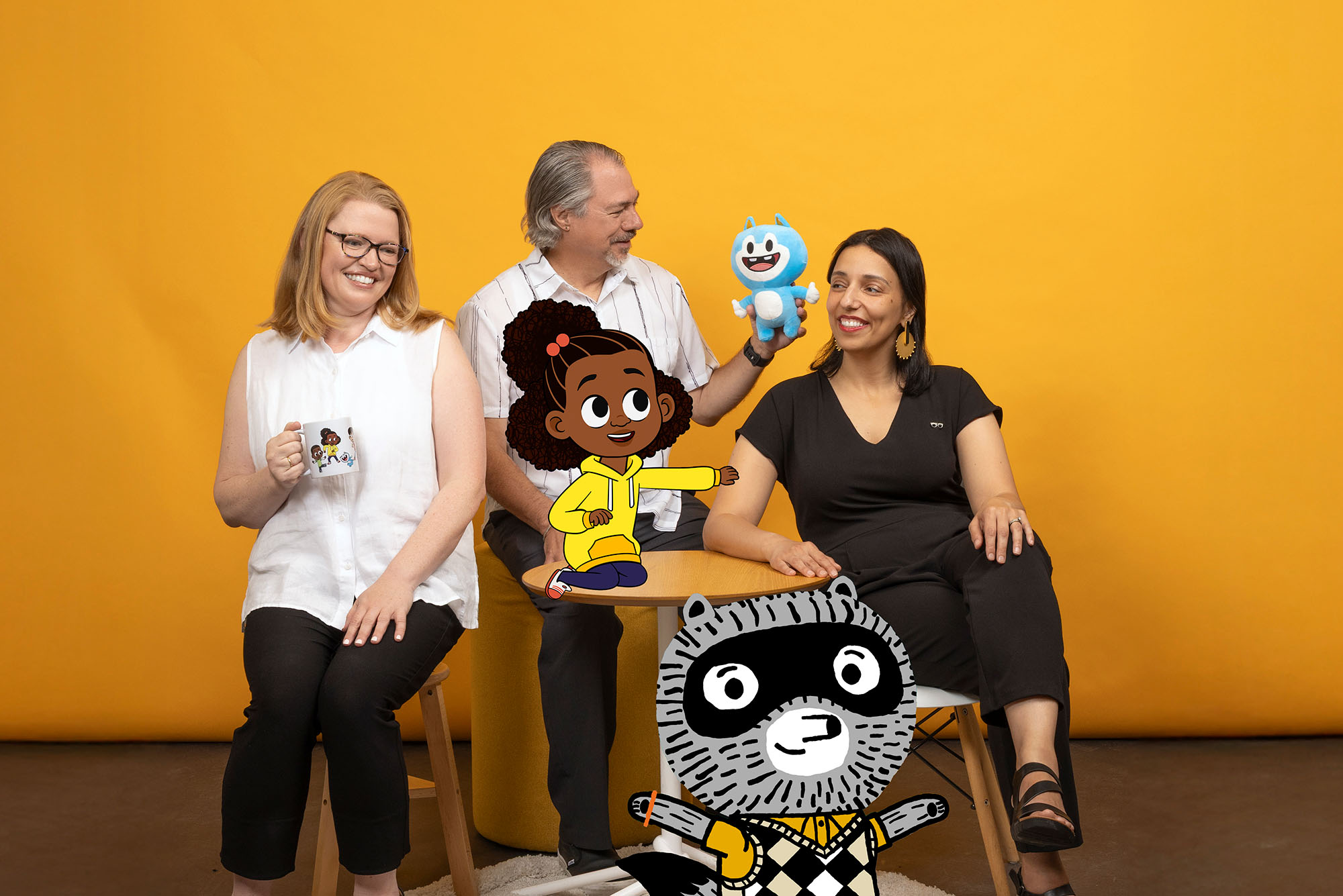 Photo: Three people smiling and posing with animations of characters from "Lyla in the Loop" and "Carl the Collector" added into the image