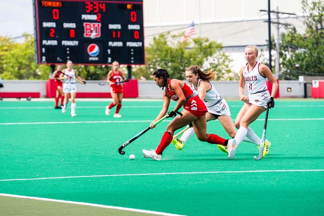 Photo: BU field hockey playing on the field in red uniforms