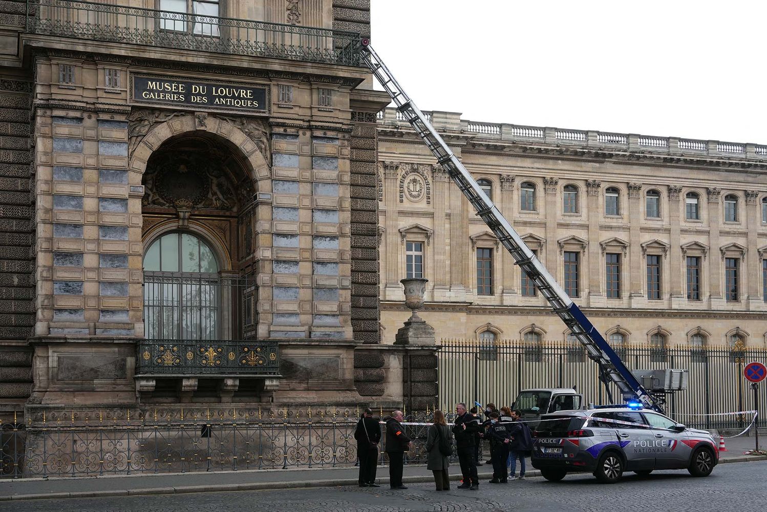 Photo: A ladder truck that thieves used to break into the louvre is being investigated by policemen outside of the museum