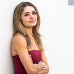 Photo: Camille Cattaui (CAS'28), a white woman with medium length highlighted hair, poses for a photo against a white wall.