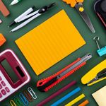 Photo: A stock image flat-lay of various school supplies on a green background.