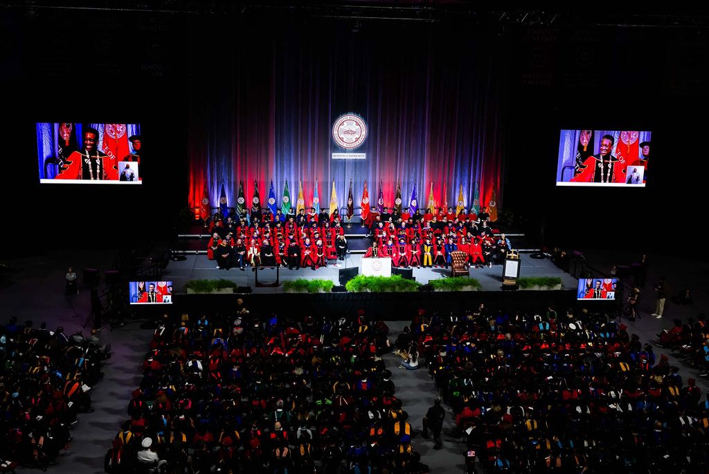 Photo: A Large crowd gathers in a dark arena to watch the inauguration of Melissa L Gilliam as Boston University's 11th President