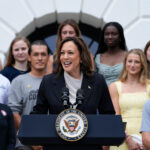 Photo: Kamala Harris, the vice president of the united states, standing in front of a large group of College Athletes at a recent speech on July 22, 2024