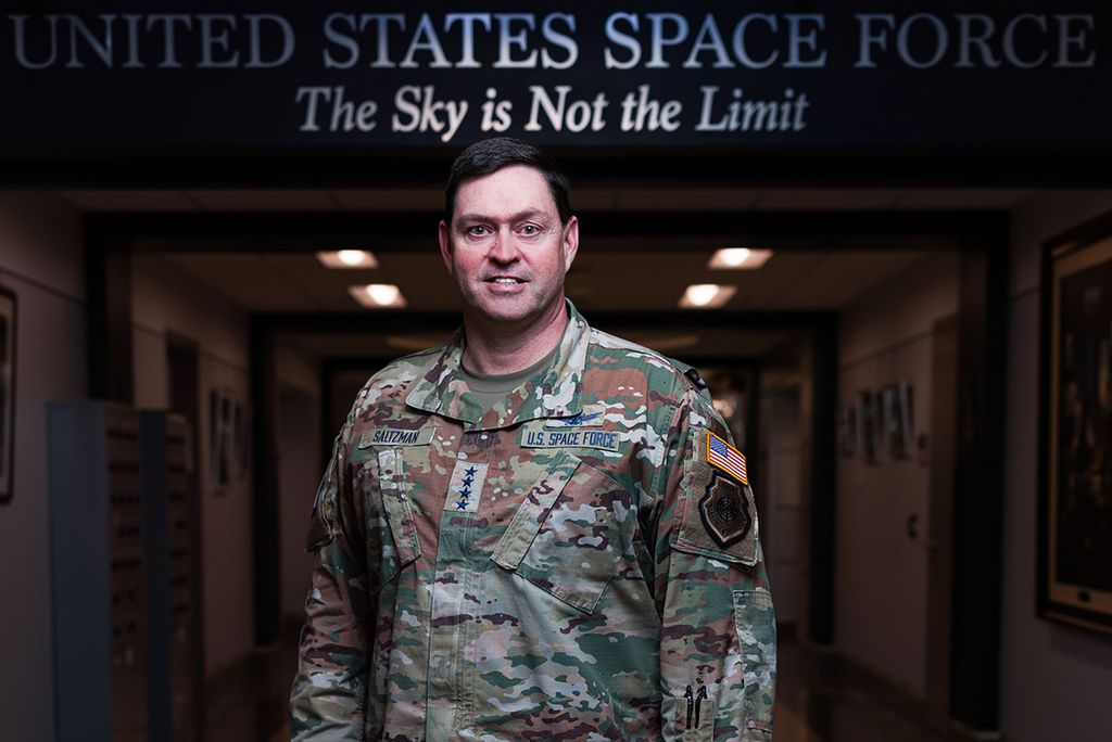 Photo: A man in a military outfit with badges and stars indicating he is a General in the US Space Force. The Banner above his head reads "United States Space Force. The Sky is Not The Limit"