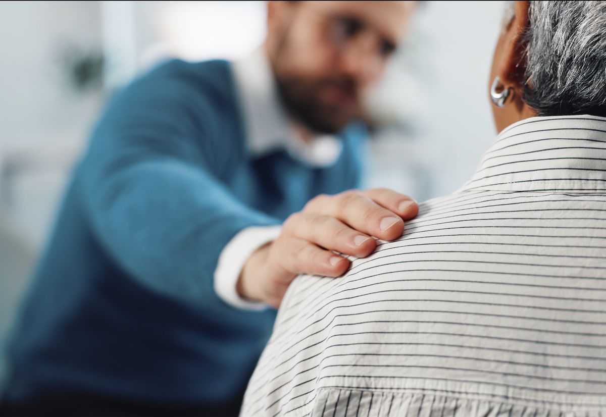 Photo: person placing their hand on another person's shoulder