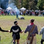 Photo: People participating in an Indigenous Peoples Day Ceremonial Celebration as they hold hands in a circle.