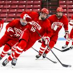 Photo: A group of hockey players on the ice skating to the right