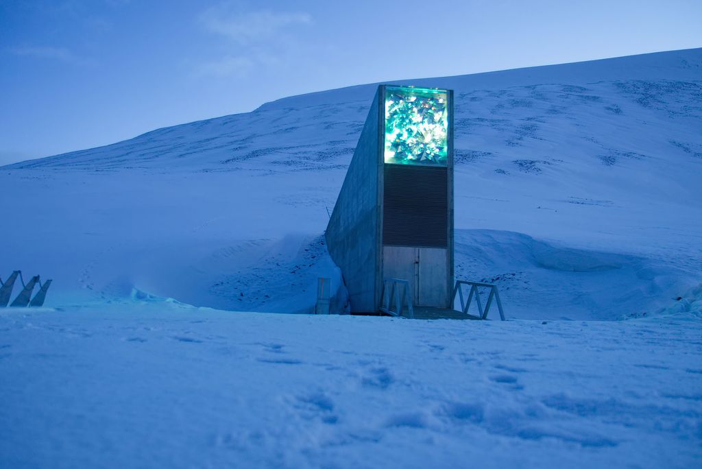 Photo: An exterior shot of the Svalbard Global Seed Vault. The building is peeking out of from a snowy mountain