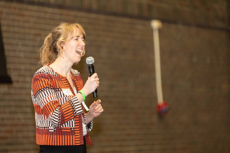 Excited woman on stage speaking into a microphone