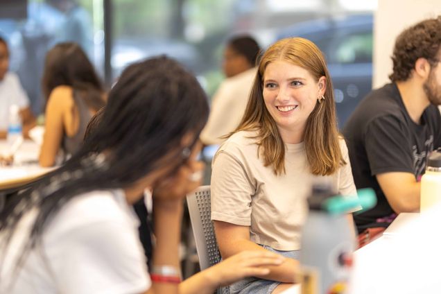 Woman smiling and listening to a student talk