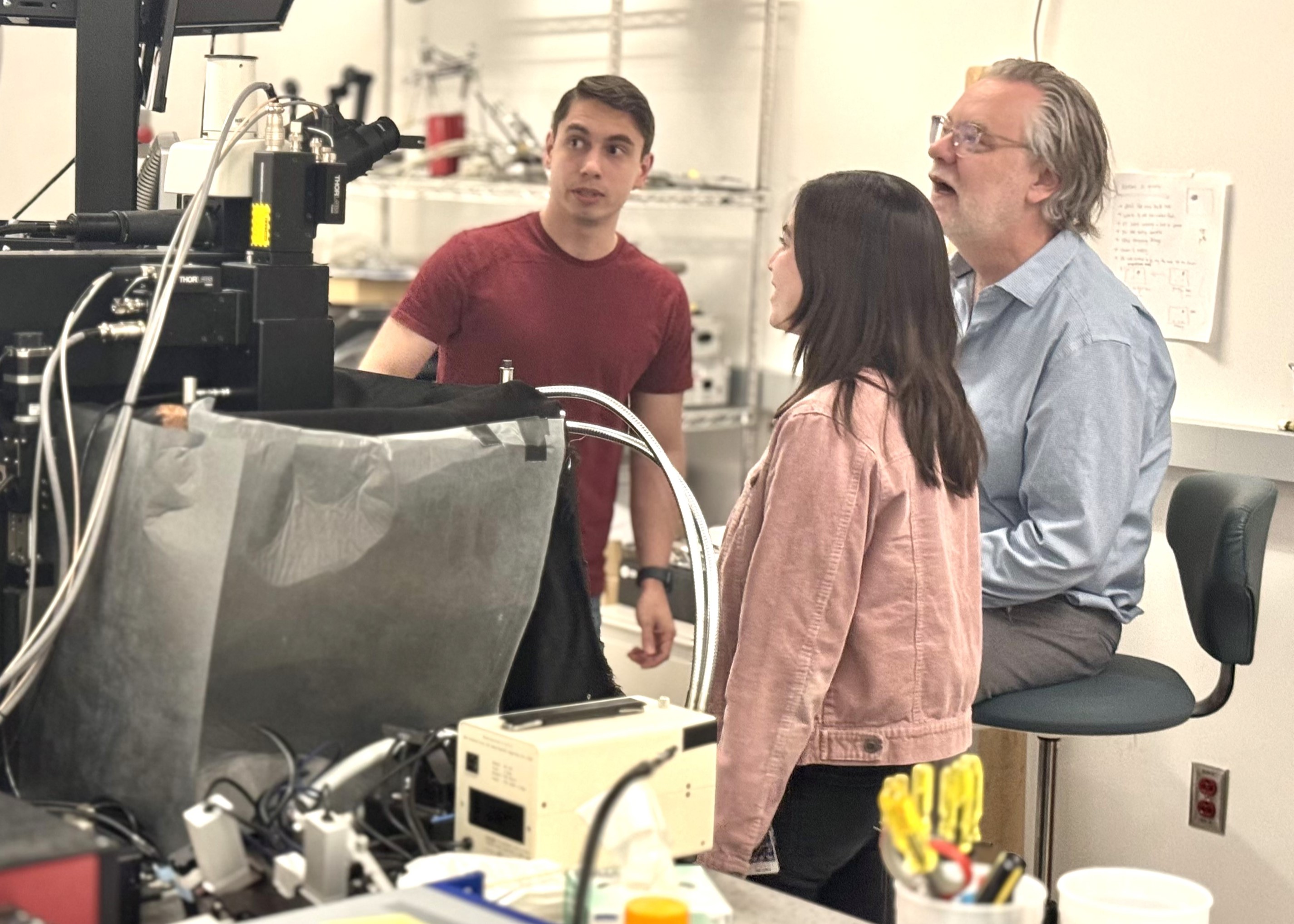 three people in a lab looking at a monitor